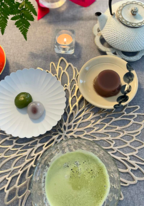 グレーのクロスを敷いた食卓でお茶と和菓子を楽しむ写真。提供されたレビュー画面から写真部分を切り出し、明るさのみ調整しています。